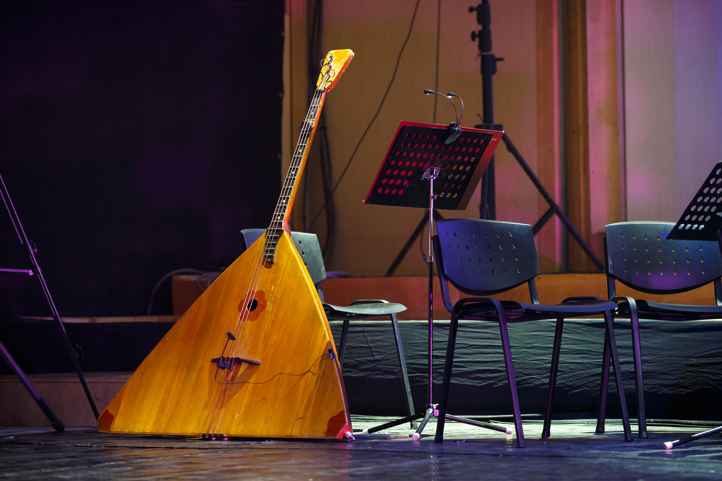 Brown  Triangle Shape Guitar Leaning on Black Metal Chair